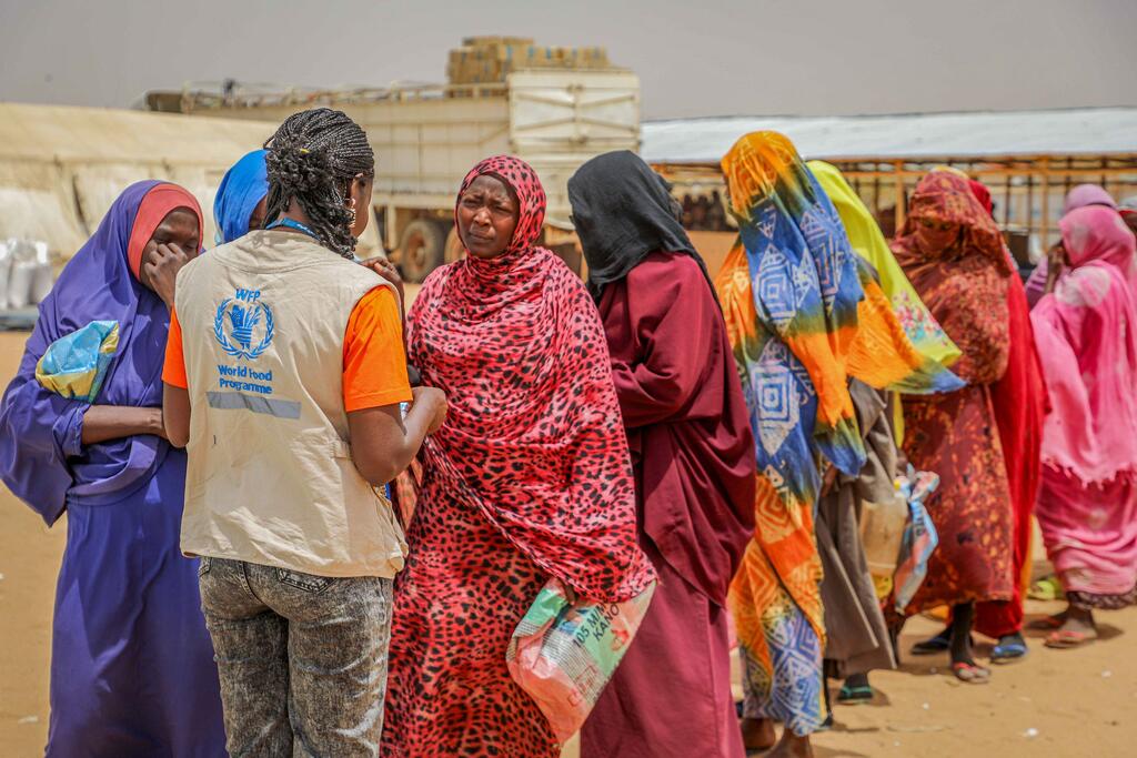 Sudanese refugees queue up for food aid distribution after having taken a biometric test to confirm their identity in Adré, Chad.